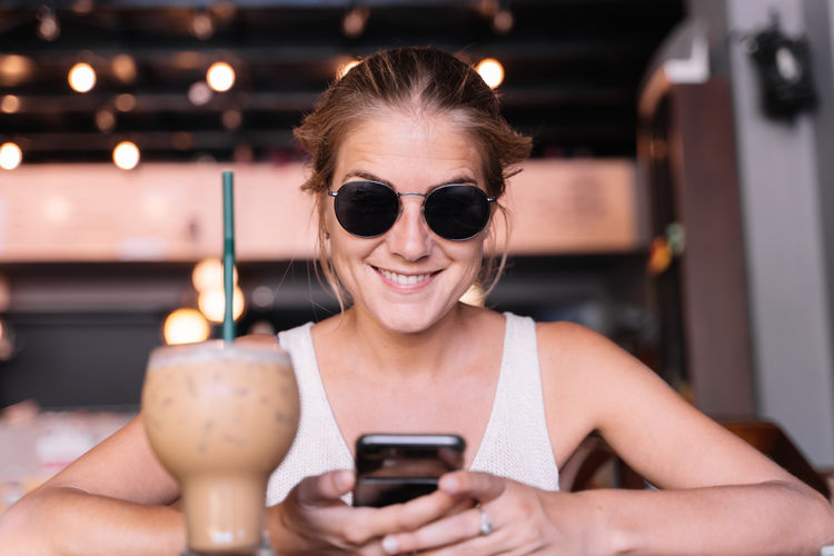 Portrait of a smiling young woman using mobile phone