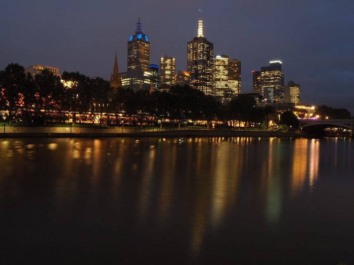River in illuminated city at night