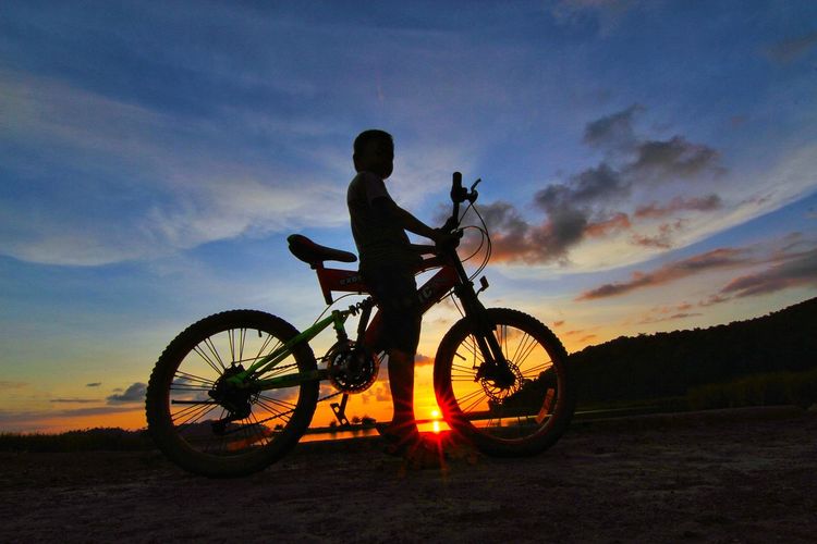 Play bikes at dusk on the beach in kuala daya, aceh jaya.