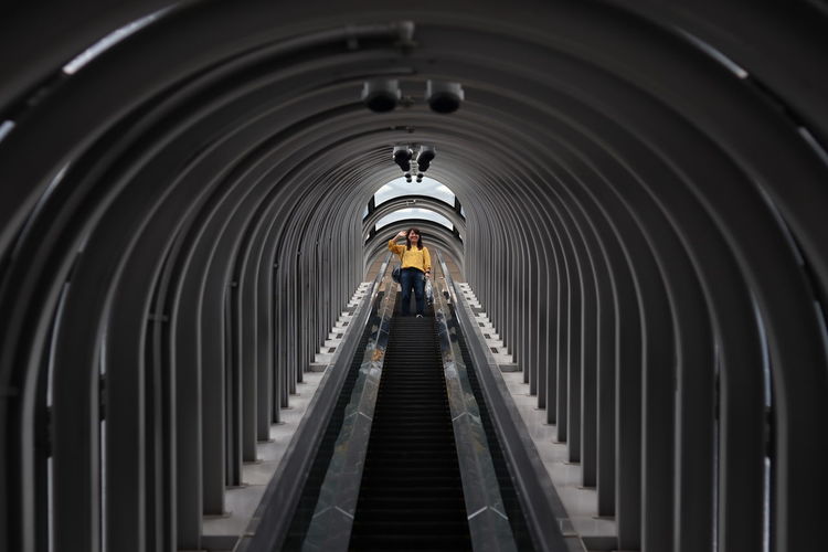 Low angle view of woman on escalator