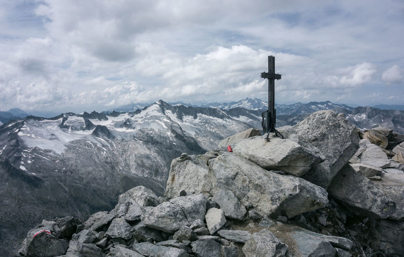 Panoramic view of cross on rock against sky