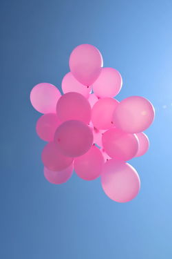 LOW ANGLE VIEW OF BALLOONS AGAINST BLUE BACKGROUND