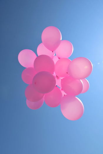 LOW ANGLE VIEW OF BALLOONS AGAINST BLUE BACKGROUND