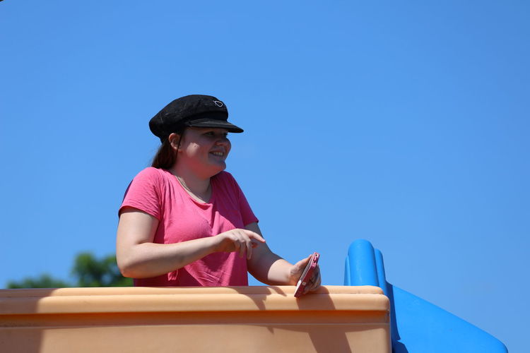 Young woman wearing hat against clear blue sky
