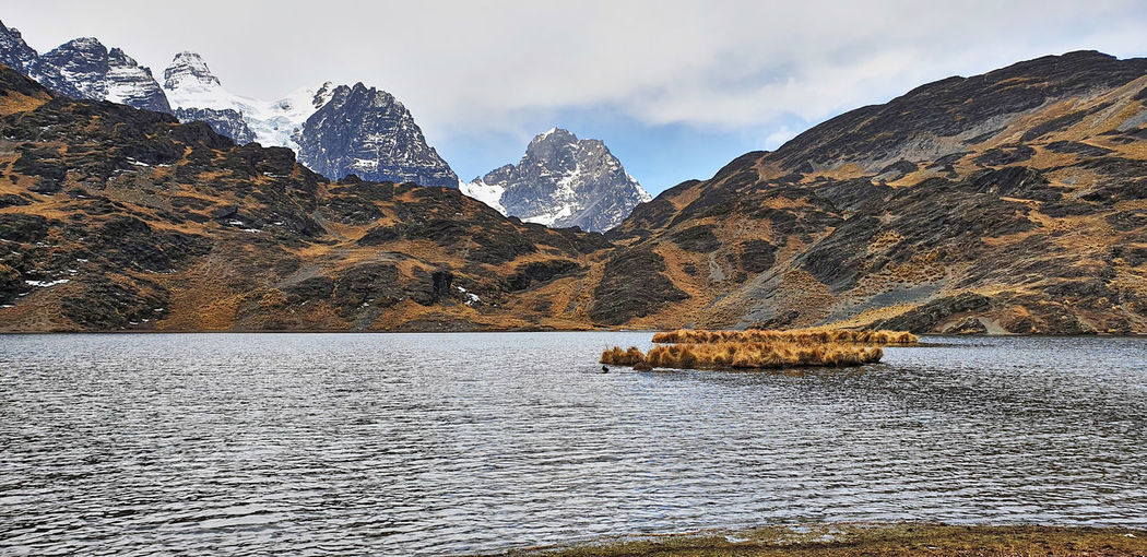 Scenic view of lake by snowcapped mountains against sky hiking trail cordillera real bolivia