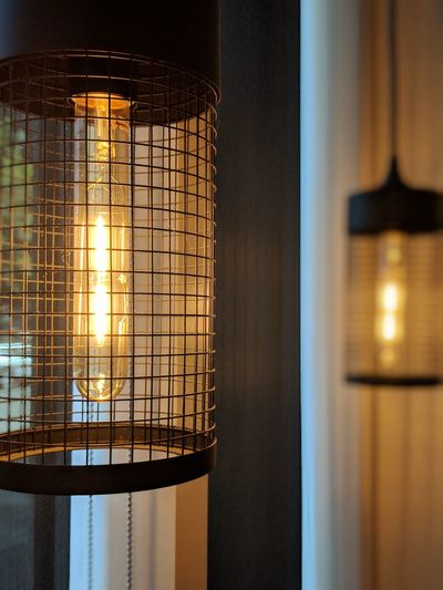 Close-up of illuminated lamp against wall at home