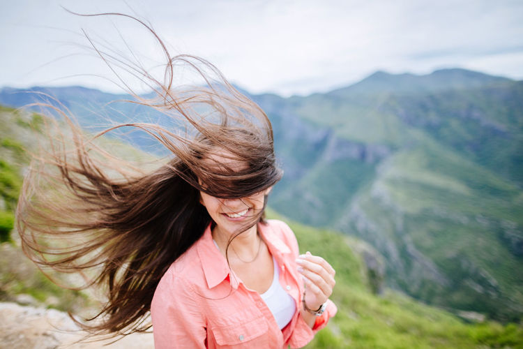 Young woman smiling against mountains