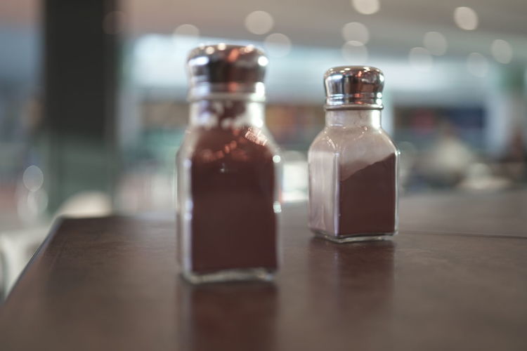 Close-up of pepper shakers on table