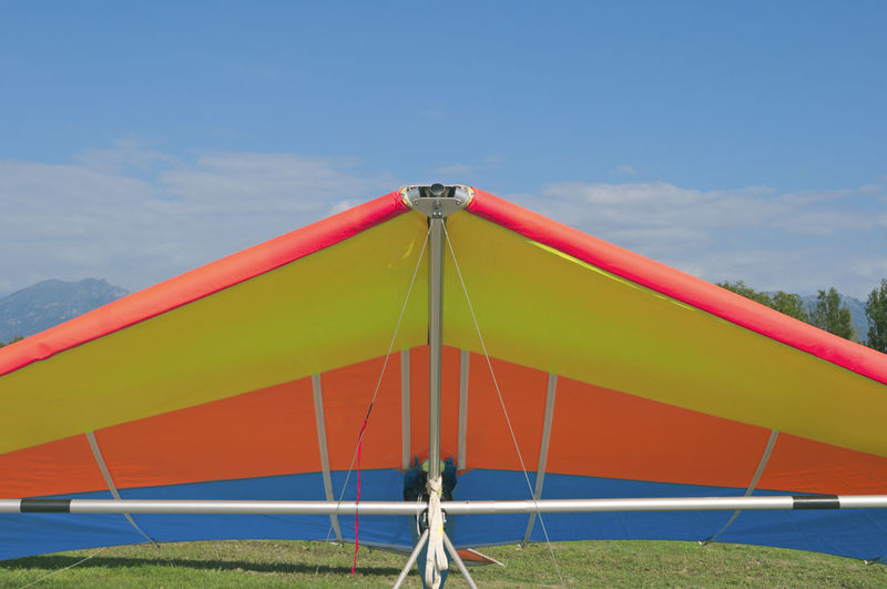 Multi colored umbrella on field against sky during sunny day