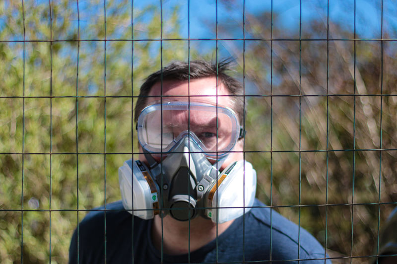 Portrait of young man holding chainlink fence