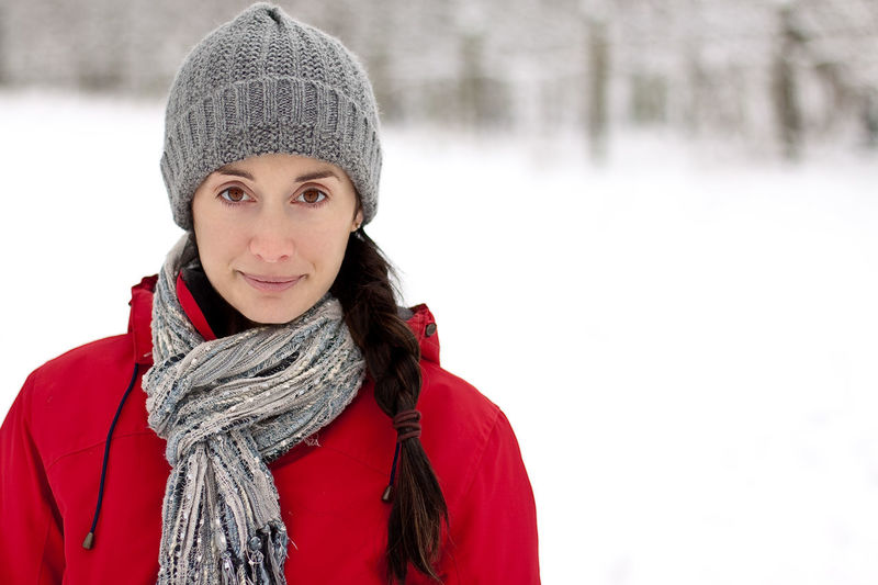 Portrait of smiling young woman in snow during winter