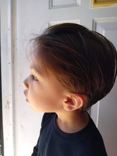 Close-up portrait of cute boy looking away at home