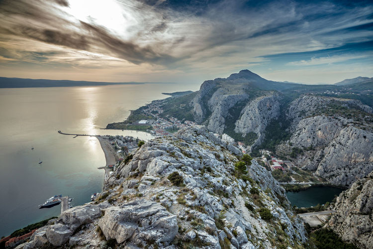 Scenic view of sea and mountains against sky