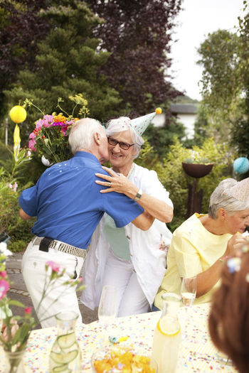 Senior man kissing elderly lady at birthday party