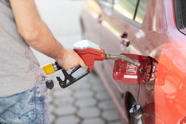 Midsection of man refueling car