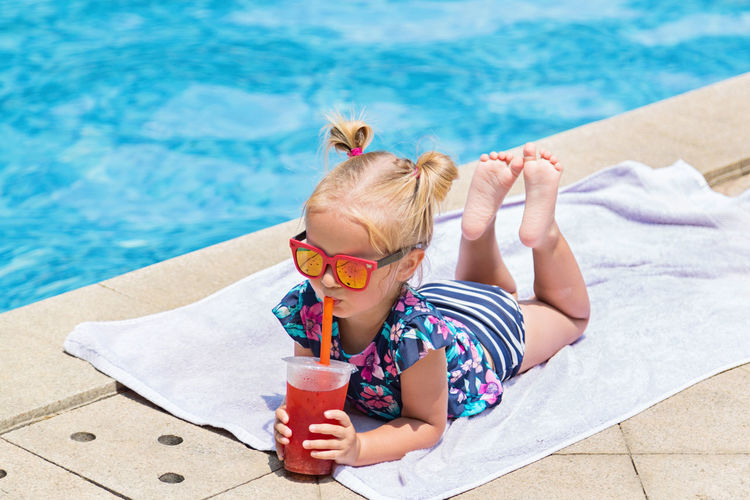 High angle view of cute boy drinking water in swimming pool
