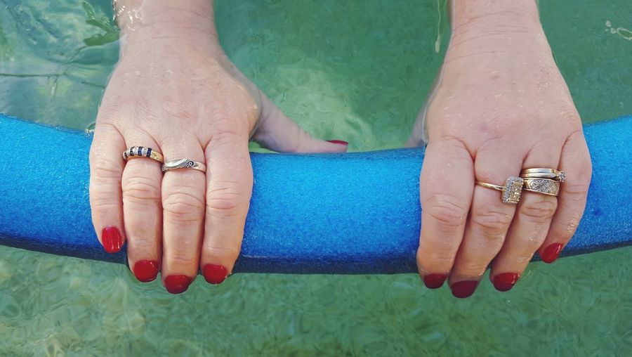 Cropped hands holding inflatable object in swimming pool
