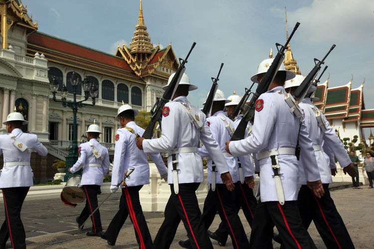 Army soldiers marching by historic building