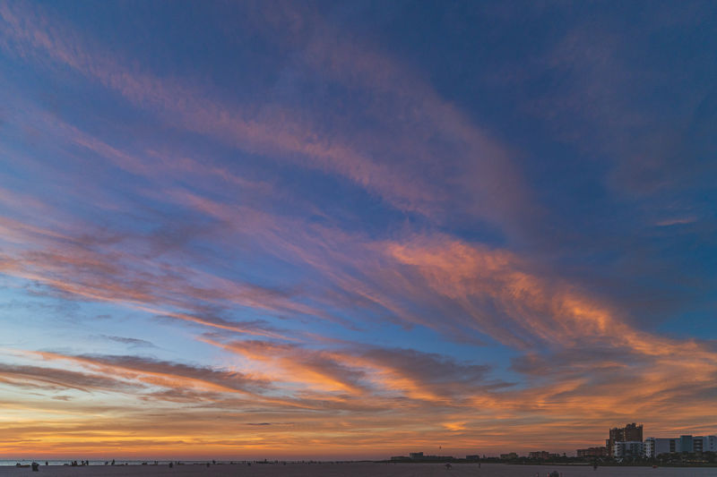 Low angle view of buildings against dramatic sky during sunset