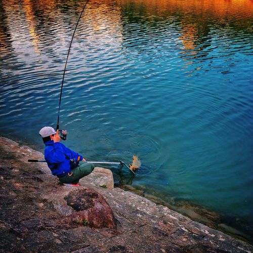 High angle view of man fishing at riverbank