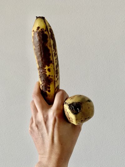 Cropped hand holding two bananas