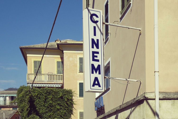 Low angle view of road sign against blue sky