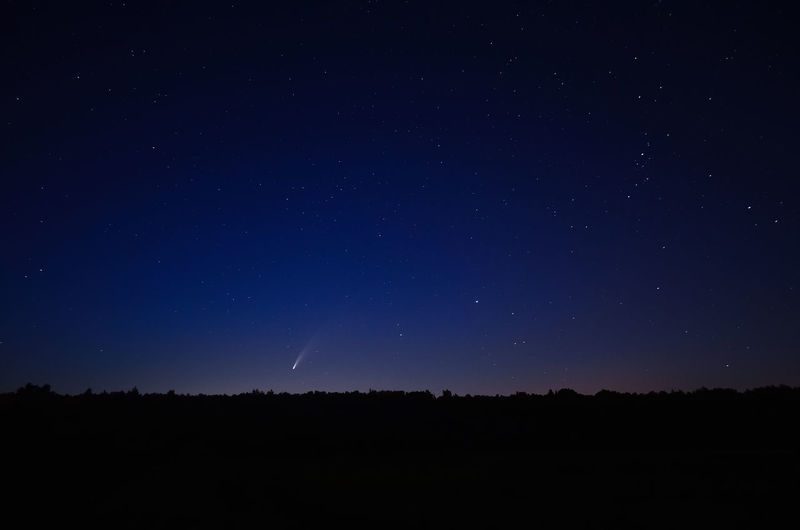 Low angle view of silhouette landscape against star field at night