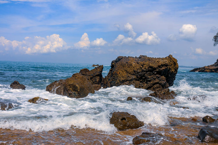 Rocks on beach against sky