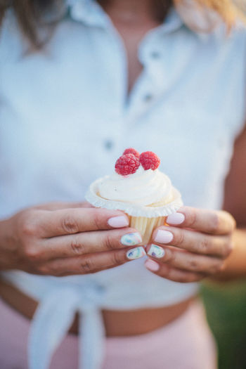 Female woman holding cupcake with strawberries in hands