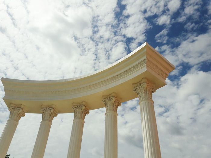 Low angle view of historic columns against sky
