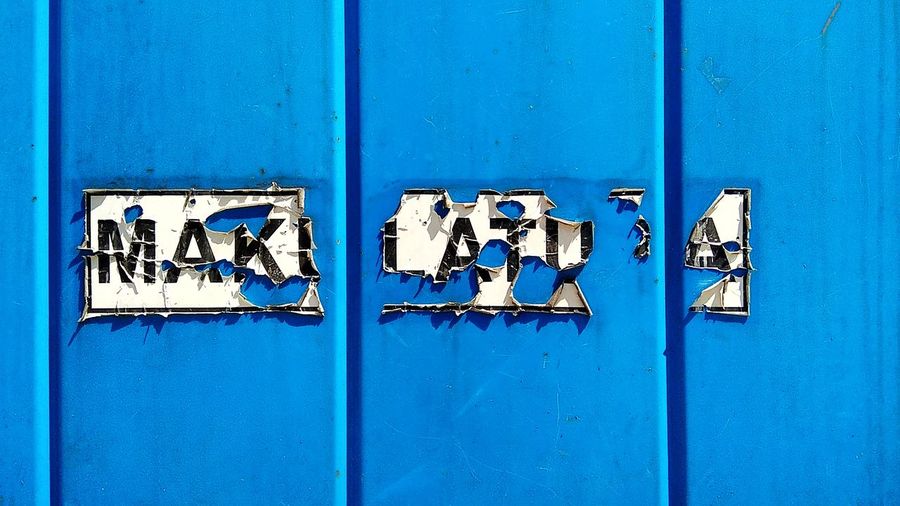 Full frame shot of text on blue wall