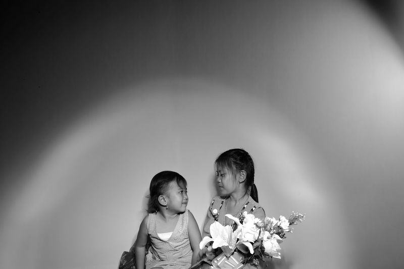Girls sitting against wall