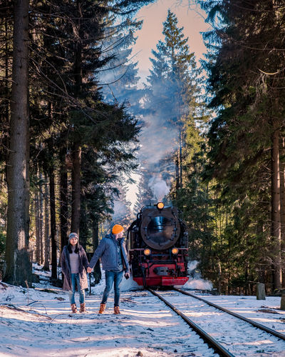 Couple standing on railroad tracks during winter