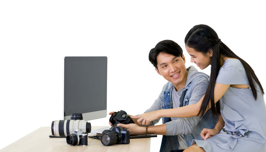 Young couple photographing against white background