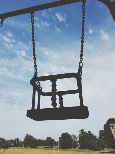 Low angle view of silhouette swing at playground