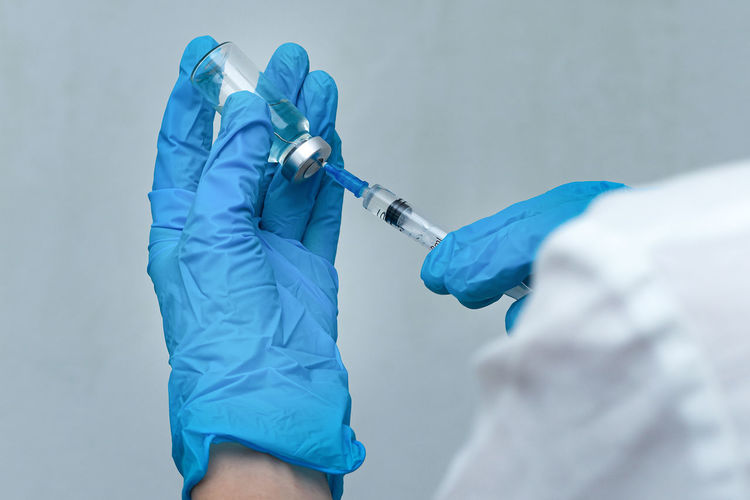 Cropped hand of doctor filling syringe with medicine