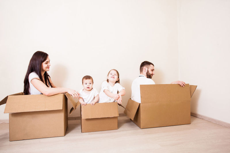 Happy family sitting in box at home