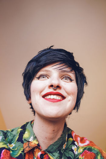 Smiling woman with make-up against colored background