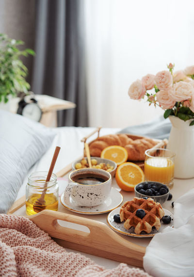 Romantic breakfast with coffee, croissants and rose flowers.