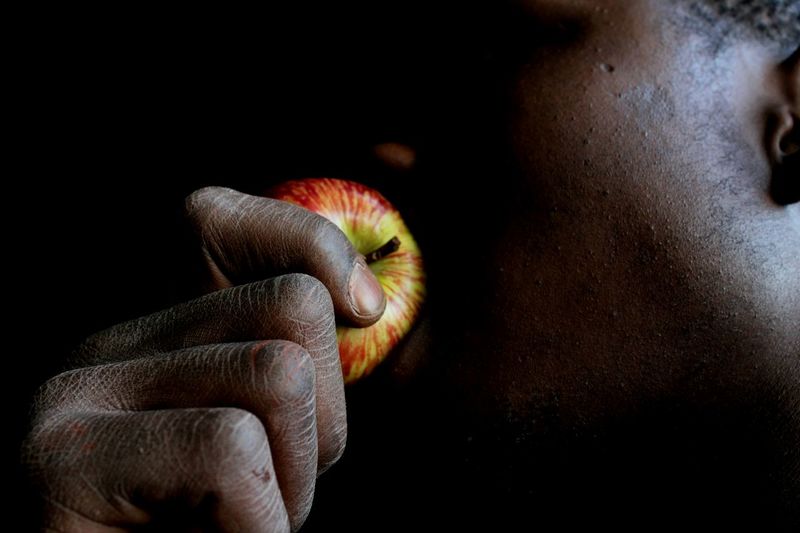 Midsection of man eating apple