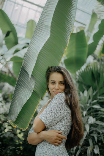 Front view of a smiling young woman amidst plants