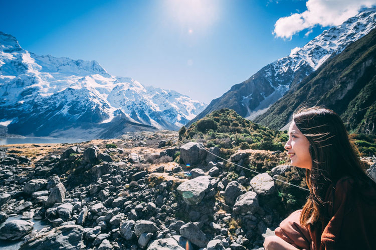 Woman on rock against sky