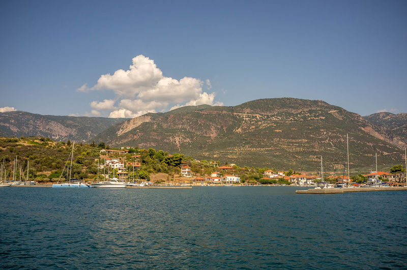 Scenic view of sea by mountains against sky