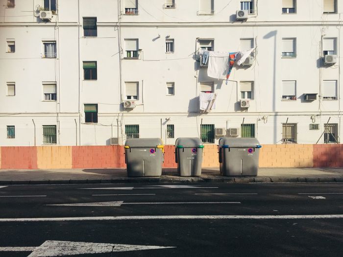 Garbage bin on street against buildings in city