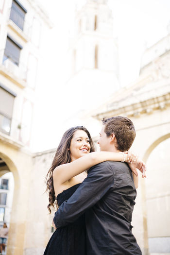 Couple embracing against historic building