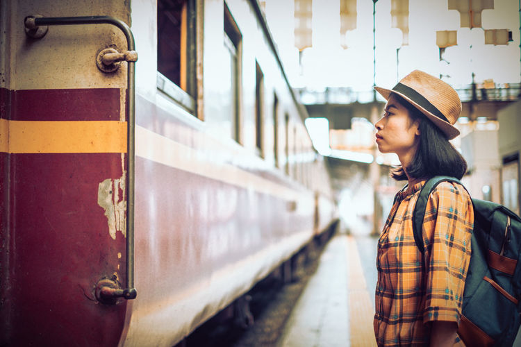 Woman standing by train at railroad station