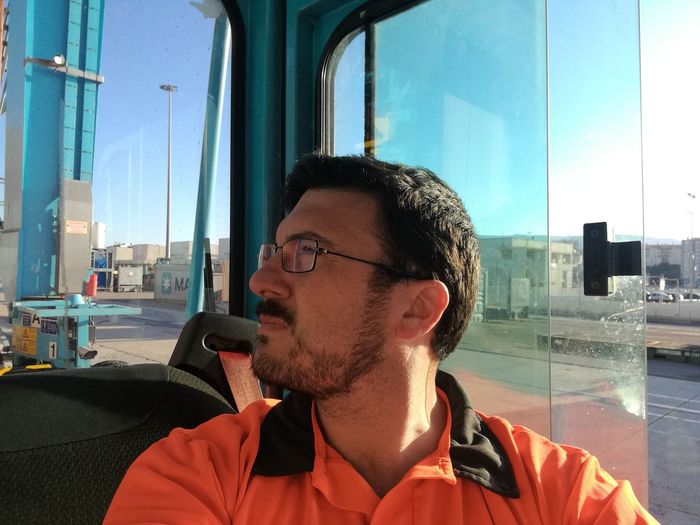 Close-up of mid adult man looking away while sitting in bus