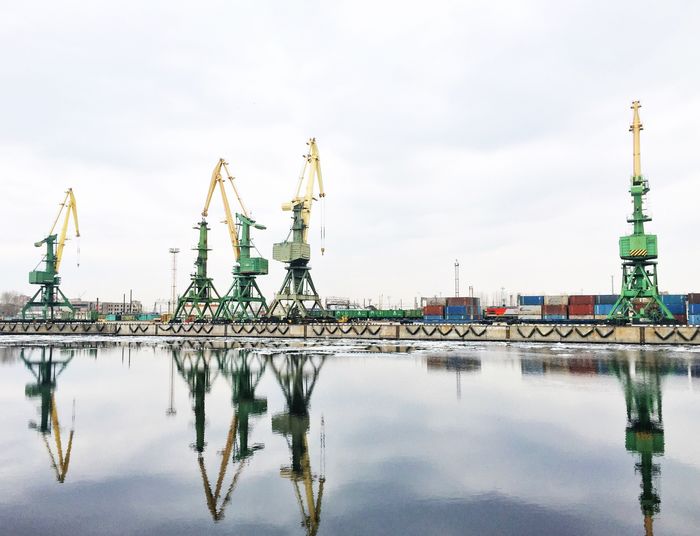 Cranes in water against sky