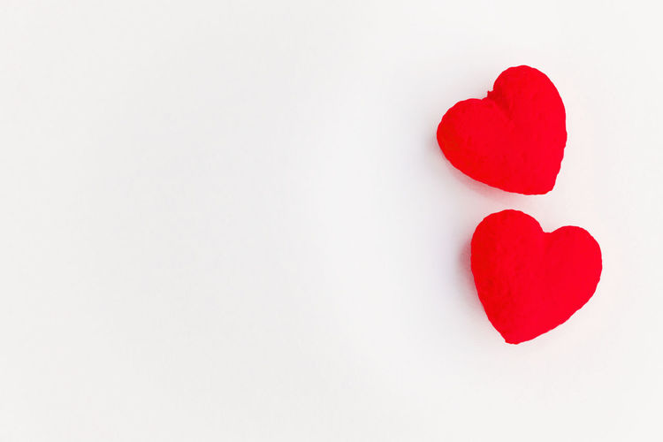 High angle view of red heart shape over white background