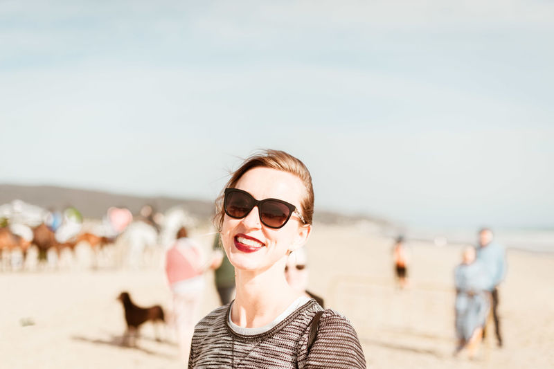 Young woman smiling in sunglasses at beach in spain
